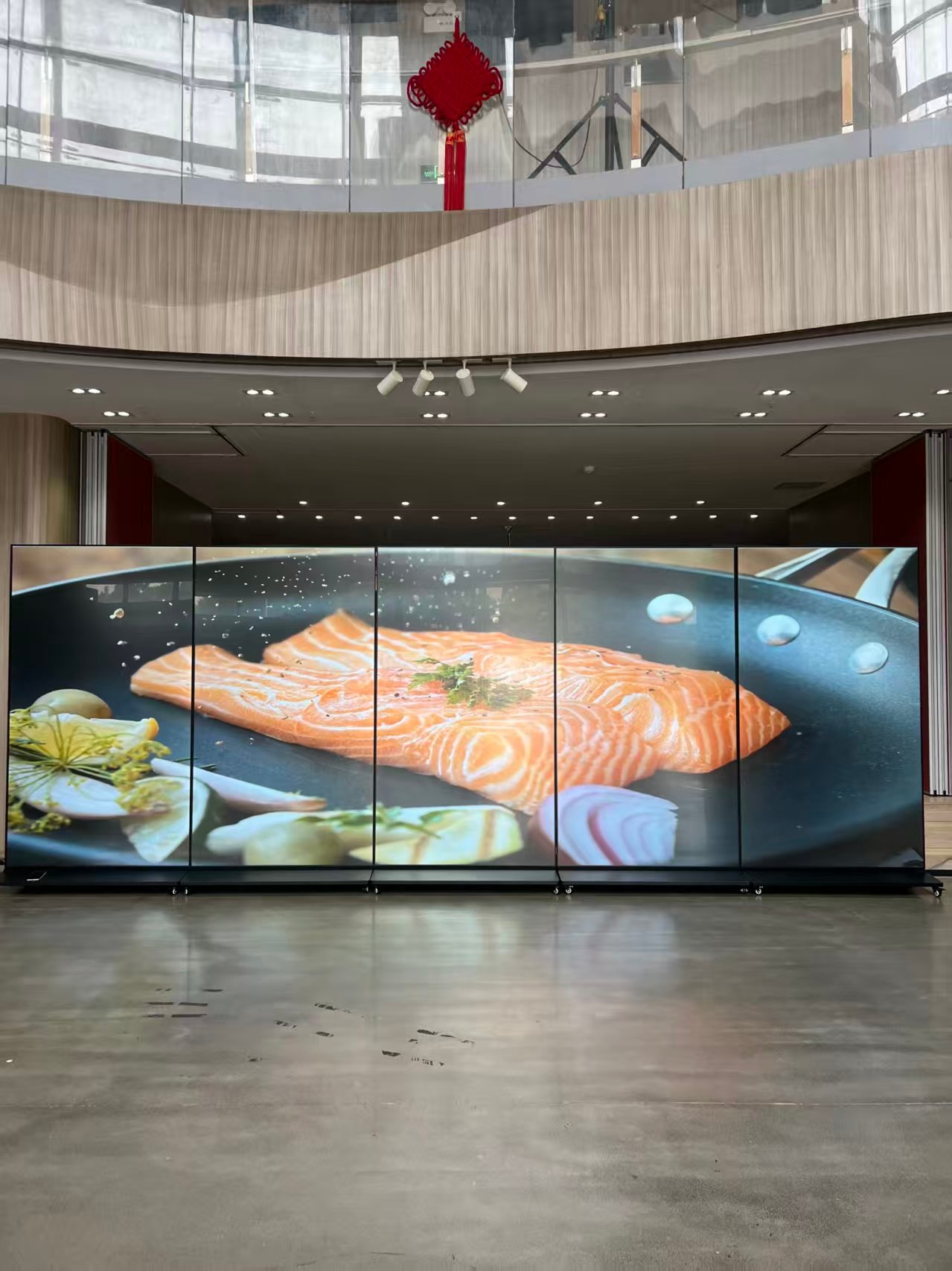 Multiple floor-standing LCD posters arranged side by side as a synchronized panoramic display wall